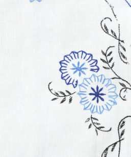 Bilden visar Broderad duk med blå langett-kant & stjälksöm detalj fram
